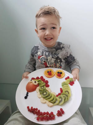 Dječak drži tanjur pun voća